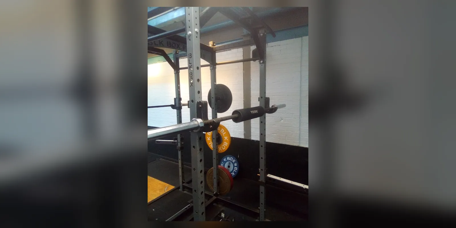 A barbell set up for back squats in a gym